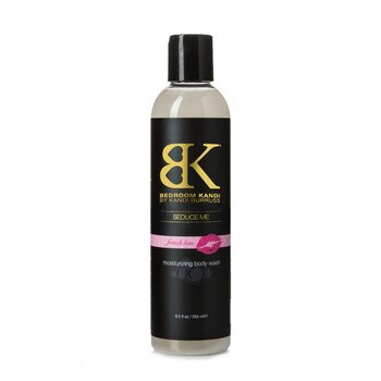 A clear round-topped bottle of Seduce Me moisturizing body wash on a white background. The bottle has a black cap, and the label says French Kiss on a pink strip with a lipstick print.